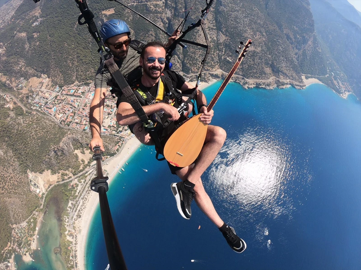 Yamaç paraşütüyle atlayan ses sanatçısı, gökyüzünde saz çalıp türkü söyledi